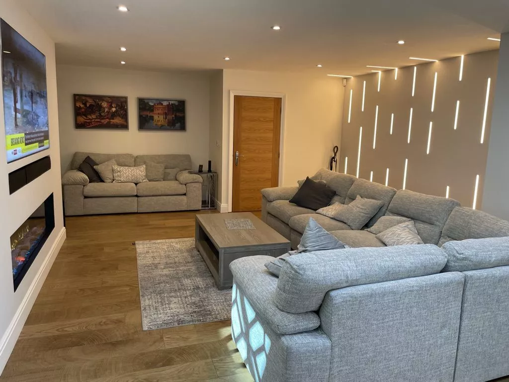 Evening view of a Control4 living room with lit vertical slots in the wall