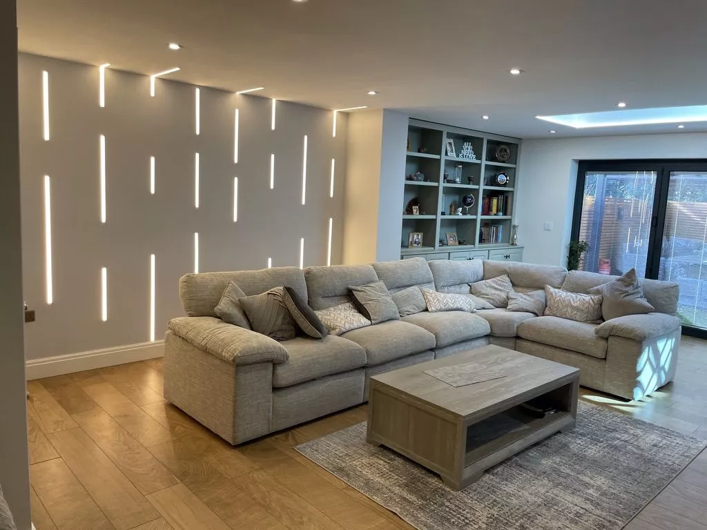 Corner sofa in front of a wall cut with vertical slots of light