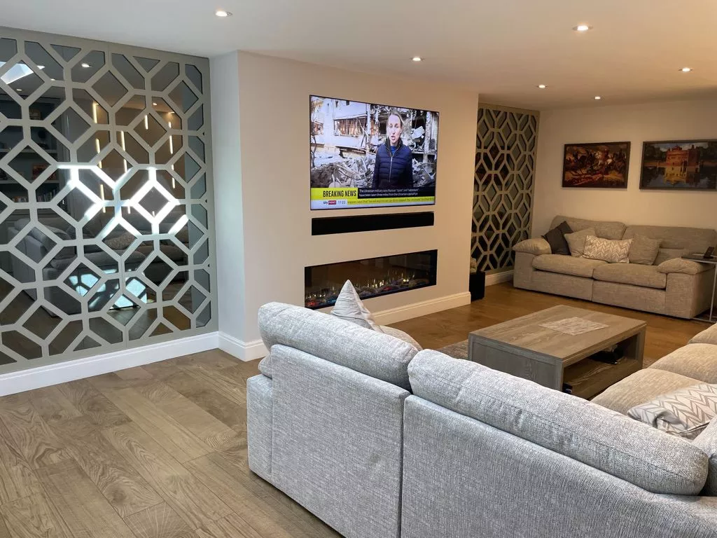 Television above a long fire in a finished Control4 media wall