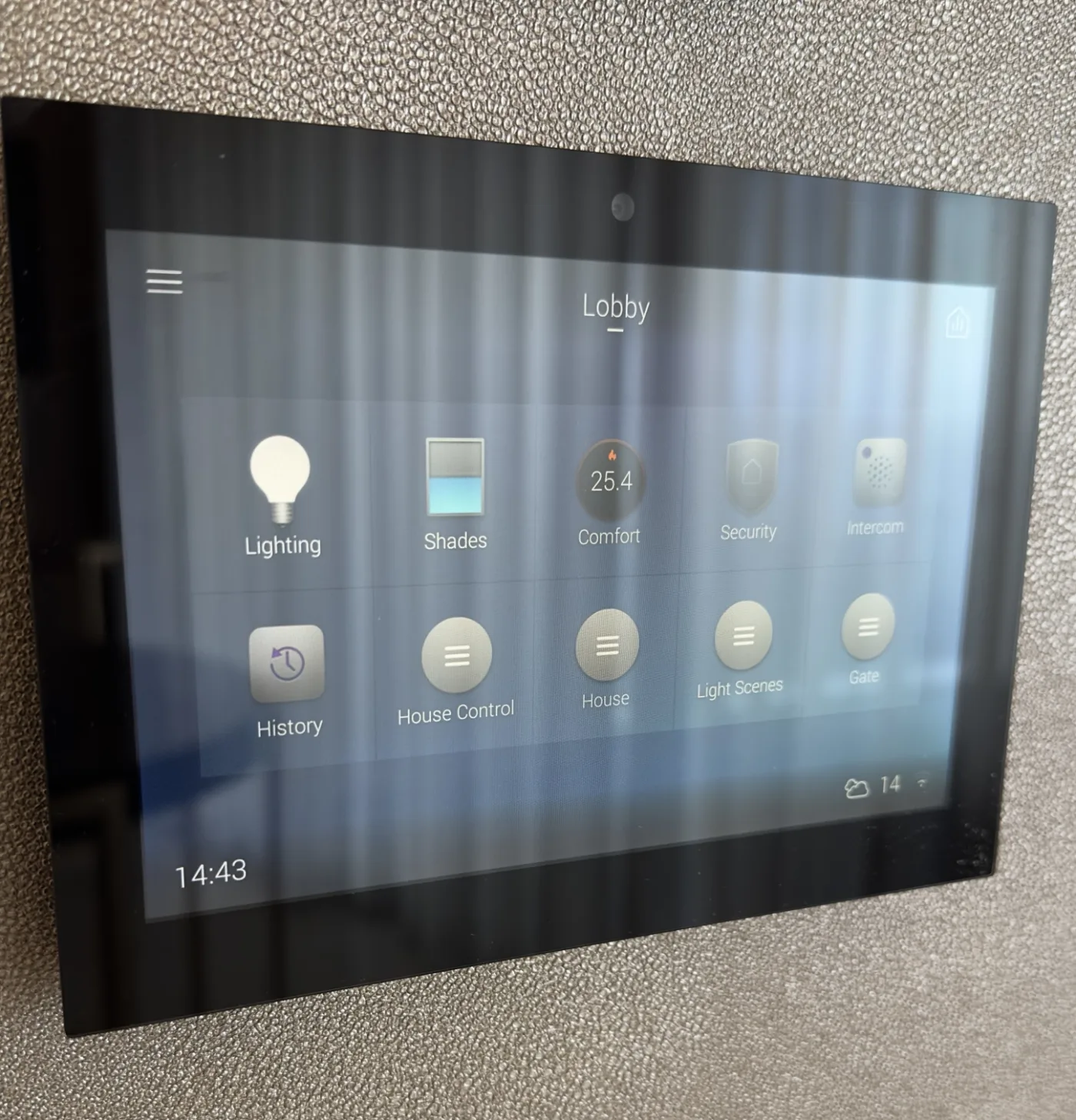 Control4 touchscreen on a hall wall showing the Lobby page: lighting, shades, comfort, security and intercom