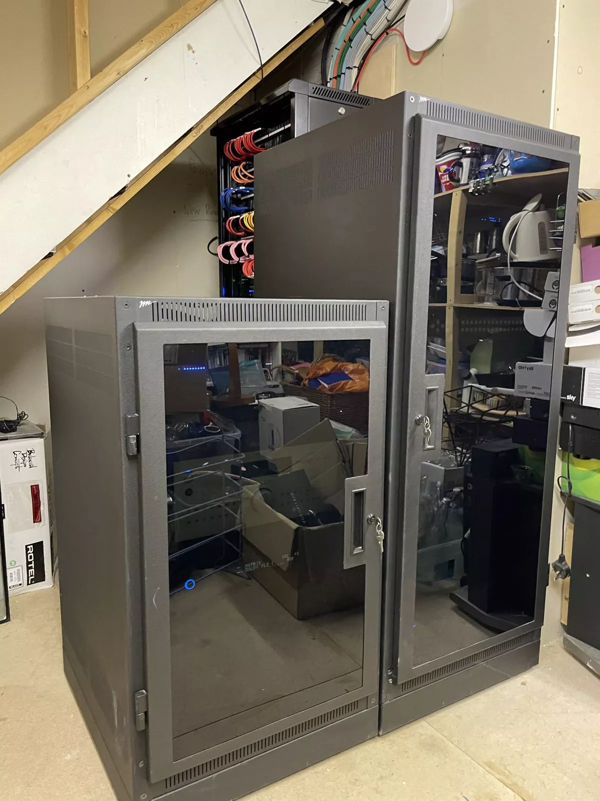 Glass cabinets housing Control4 equipment under a staircase